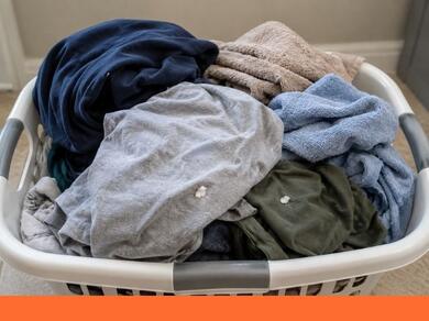 Wasmand met kleding en zichtbare lijmvlekken