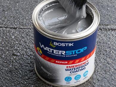 Bostik Waterproofing Repair Spray positioned beside a roof gutter for sealing leaks and protecting external roof details