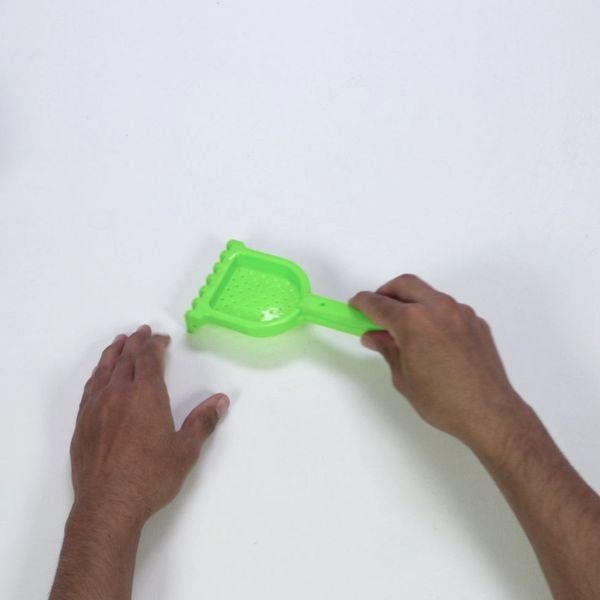 Person using plastic toy spade AU