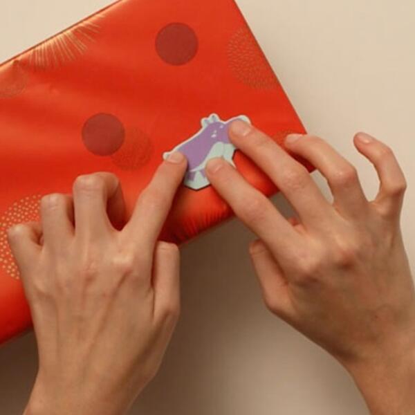 Applying animal sticker to a wrapped storage box